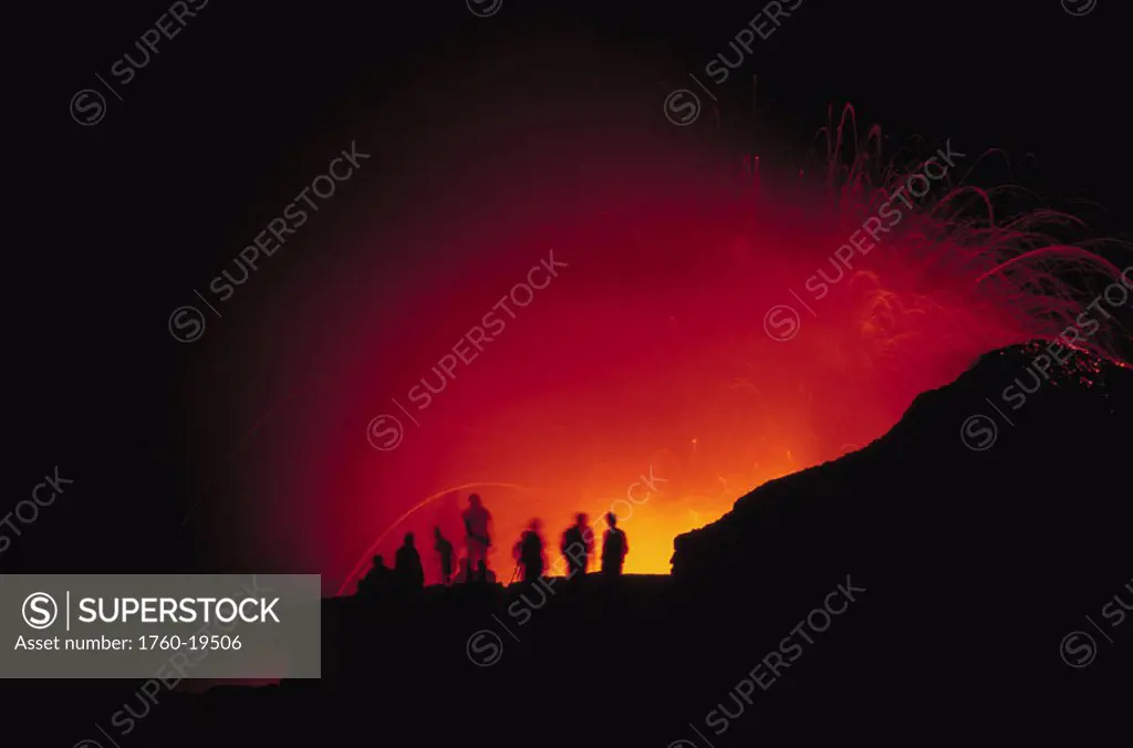 Hawaii, Big Island, Visitors view a glowing explosion of lava at night