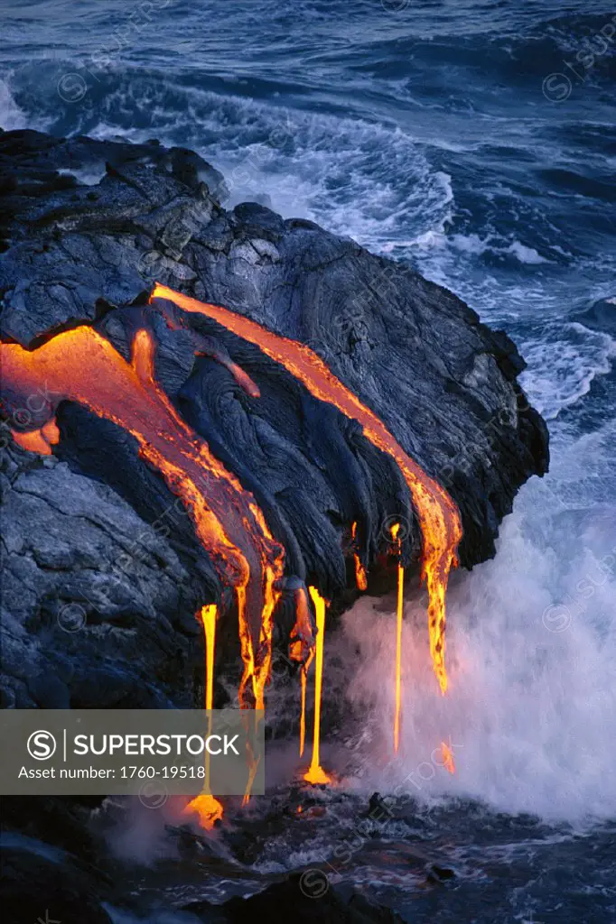 Hawaii Volcano National Park closeup lava flowing into gray ocean, steam smoke pahoehoe