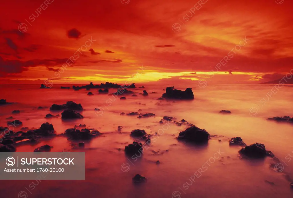 Hawaii, Maui, Lava rock beach at sunset with dramatic red yellow sky and shore