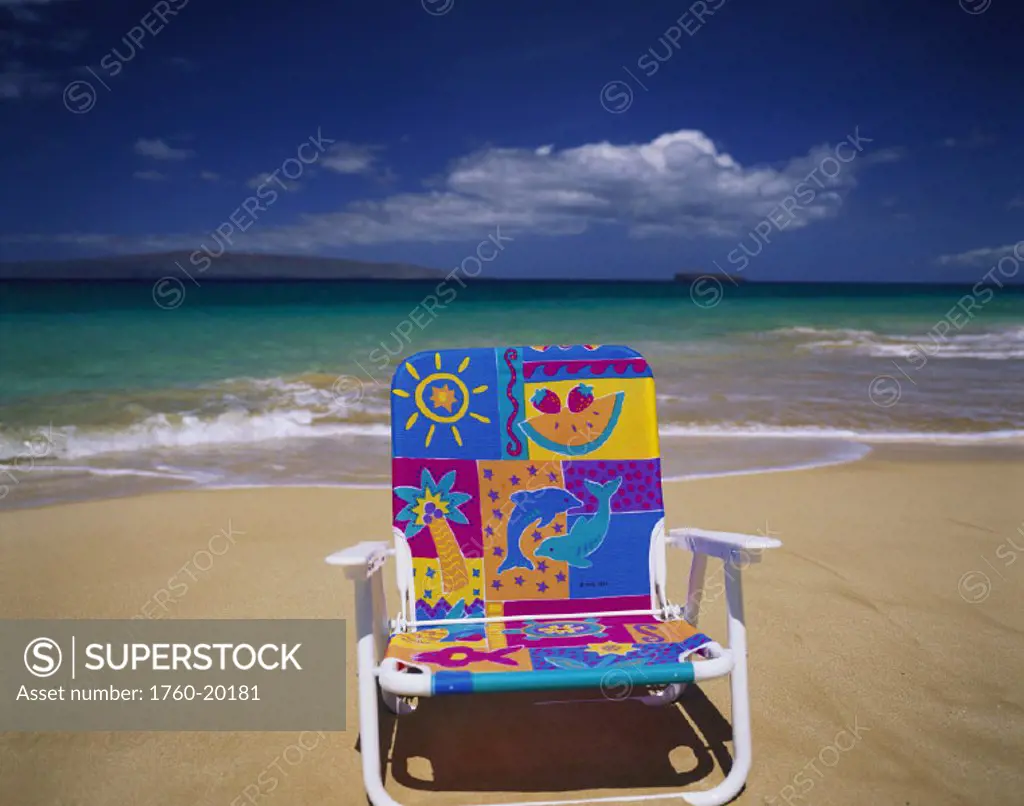 Hawaii, Maui, Makena State Park, Big Beach, colorful beach chair on beach with calm waves washing ashore turquoise water