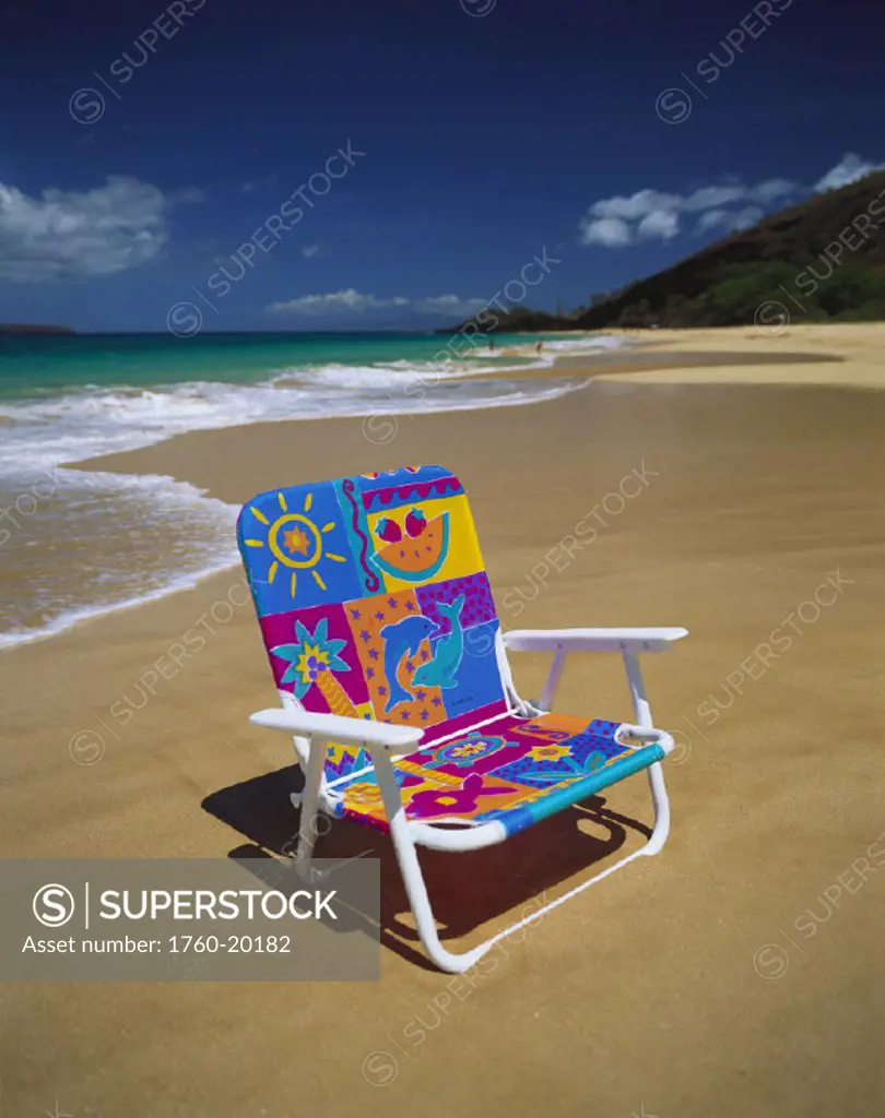 Hawaii, Maui, Makena State Park, Big Beach, colorful beach chair on beach with calm waves washing ashore turquoise water