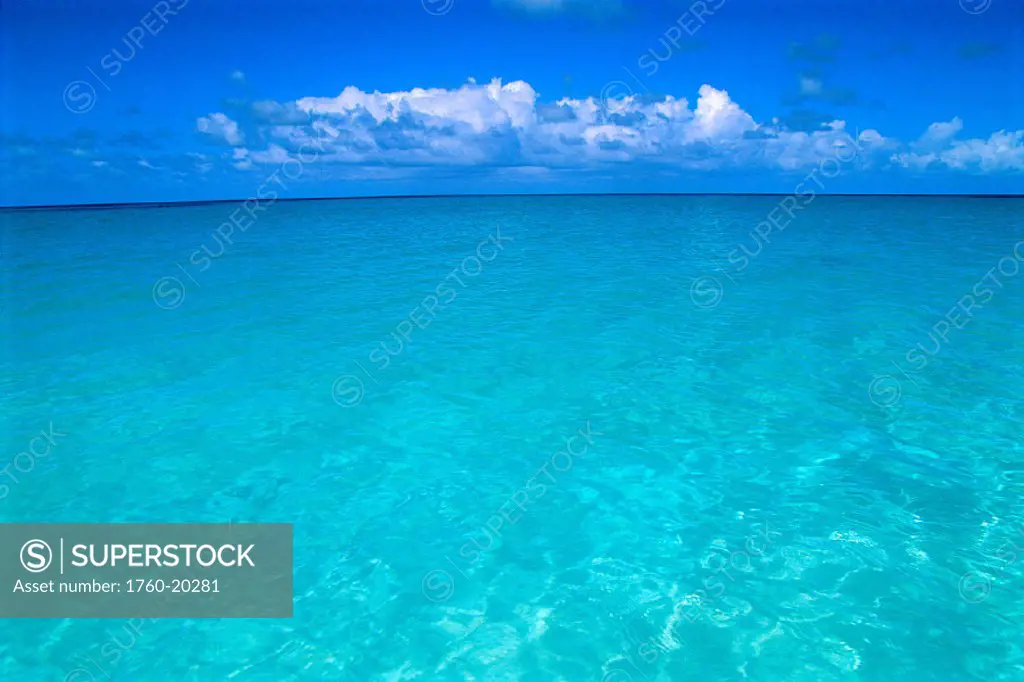 Beautiful turquoise water, calm and clear to horizon, clouds in blue sky