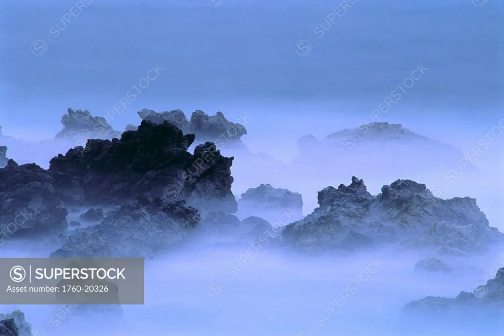 Misty fog layer over lava rocks, ocean shoreline
