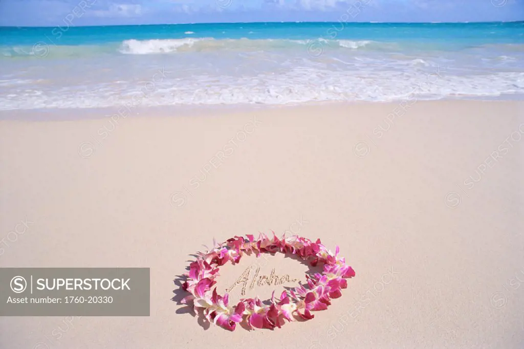 Hawaii, purple orchid lei,  Aloha written in the sand, turquoise ocean background