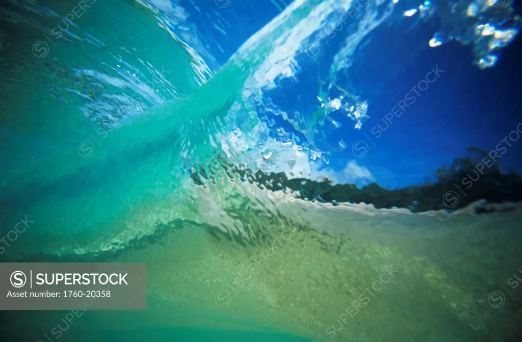 Hawaii, Oahu, Underwater view through curling shoreline wave.