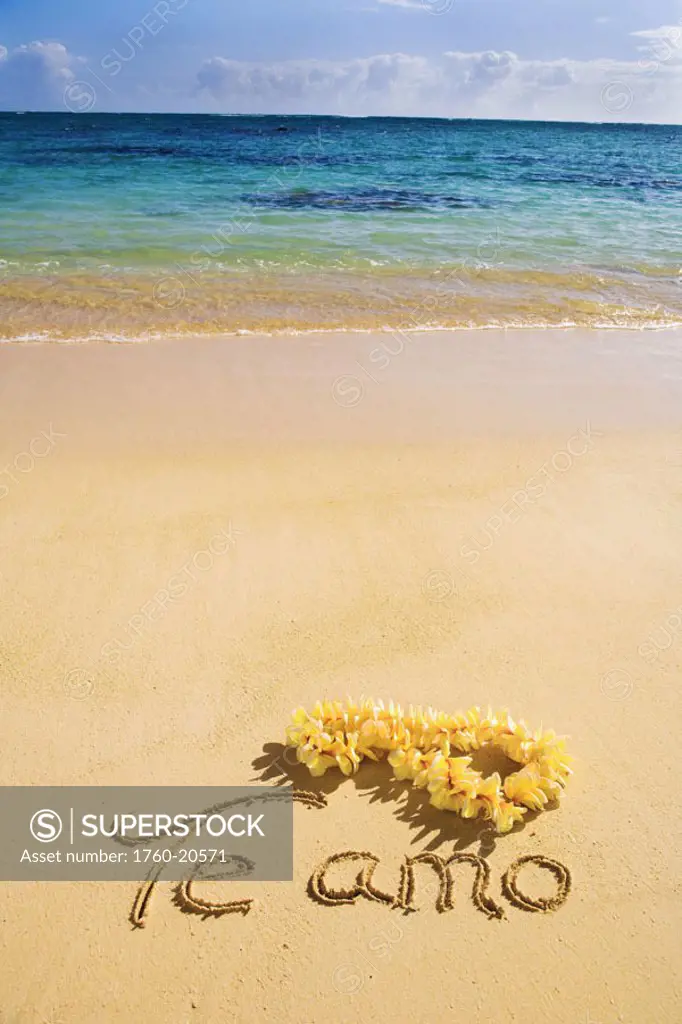 Hawaii, Oahu, Lanikai Beach ´Te amo´ written in the sand with yellow plumeria lei, turquoise ocean