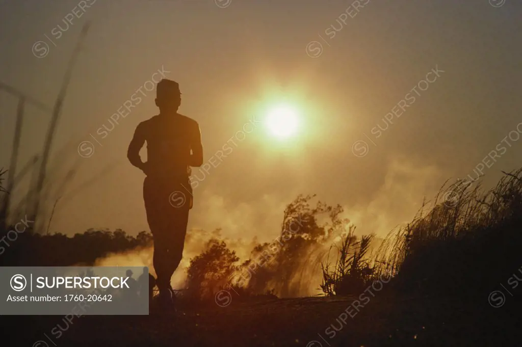 Hawaii, Big Island, Hawaii Volcanoes National Park, Volcano Marathon and Rim Run, silhoutte of man running with sunball behind.