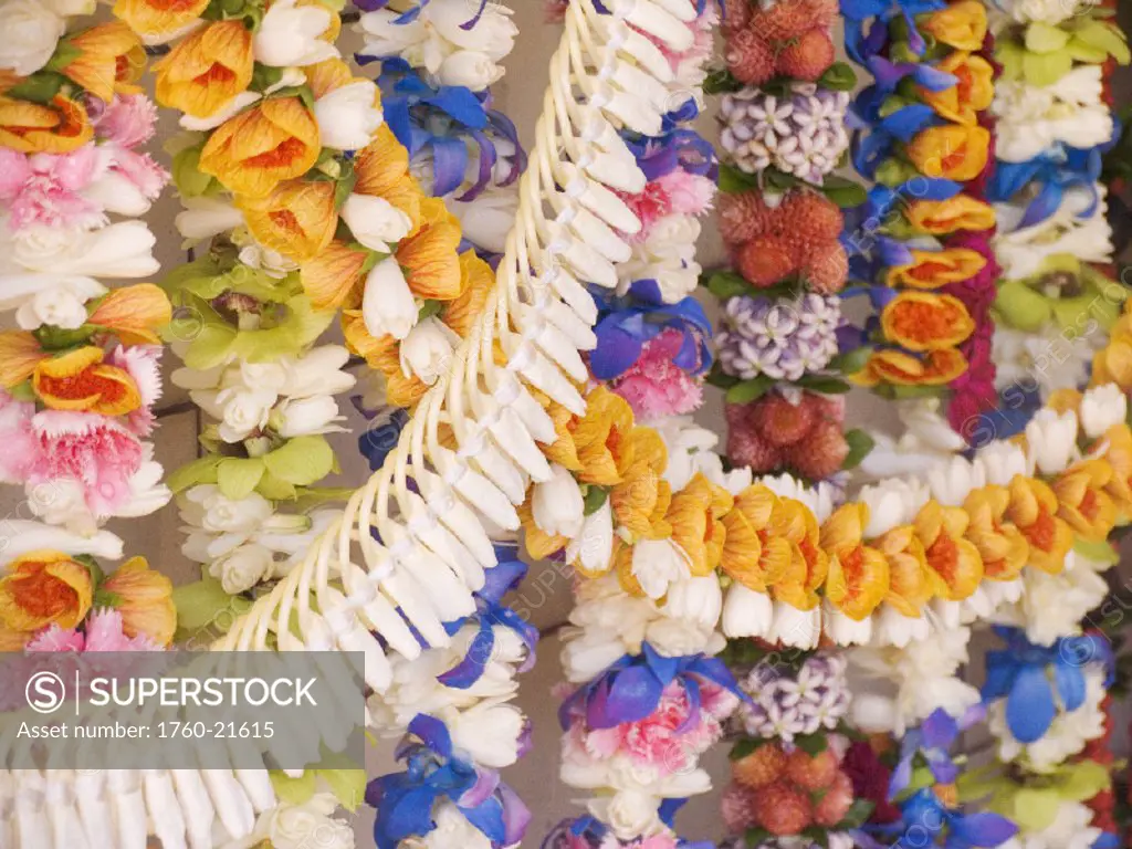 Close-up of many strings of colorful leis.