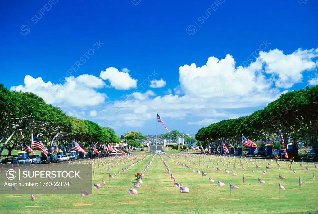 Hawaii, Oahu, Punchbowl Cemetary, American flag in distance, graves with individual flags surrounding