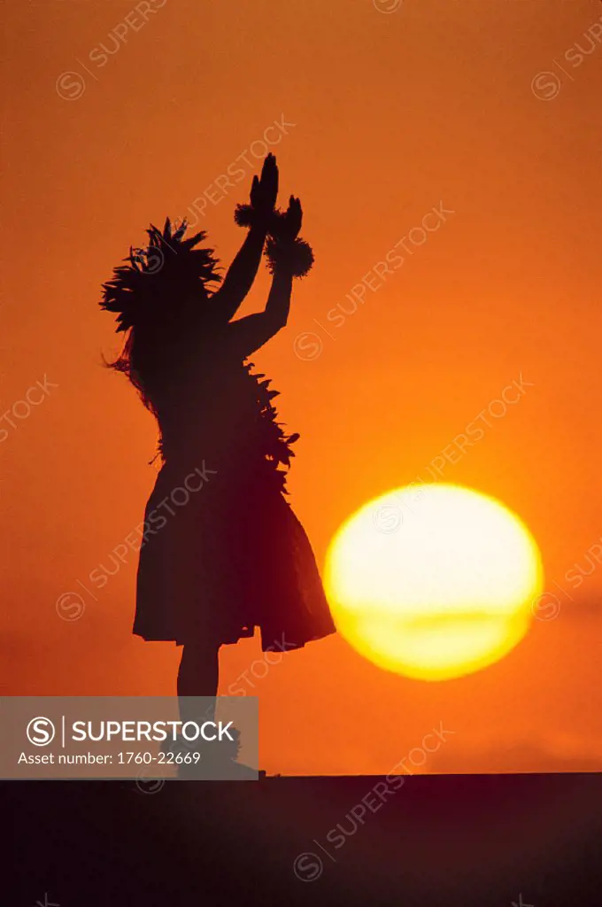 Hawaii, Woman kahiko hula silhouetted in orange skies, large golden sunball