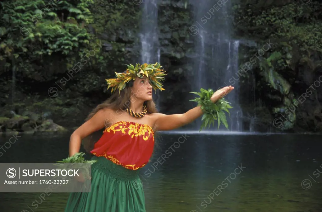 Hawaiian woman wearing hula attire, waterfall background, with haku
