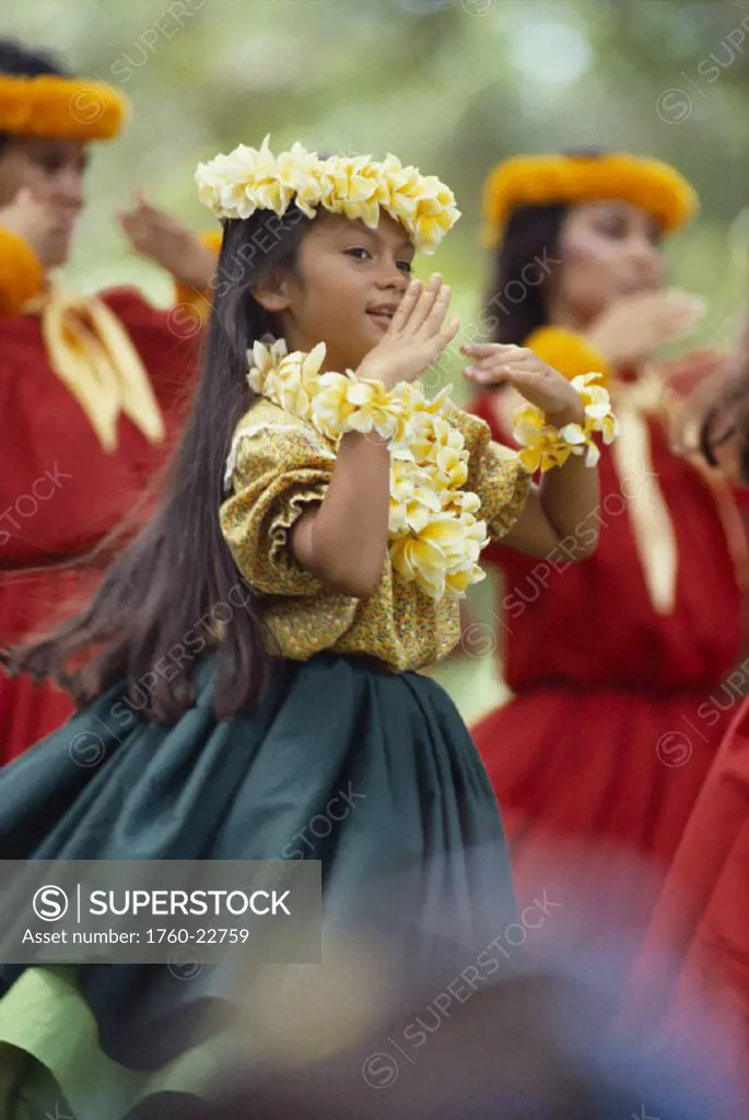 Hawaii, Oahu, Keiki Hula, view of young girl with plumeria lei and haku, hands in front  of face, women in background