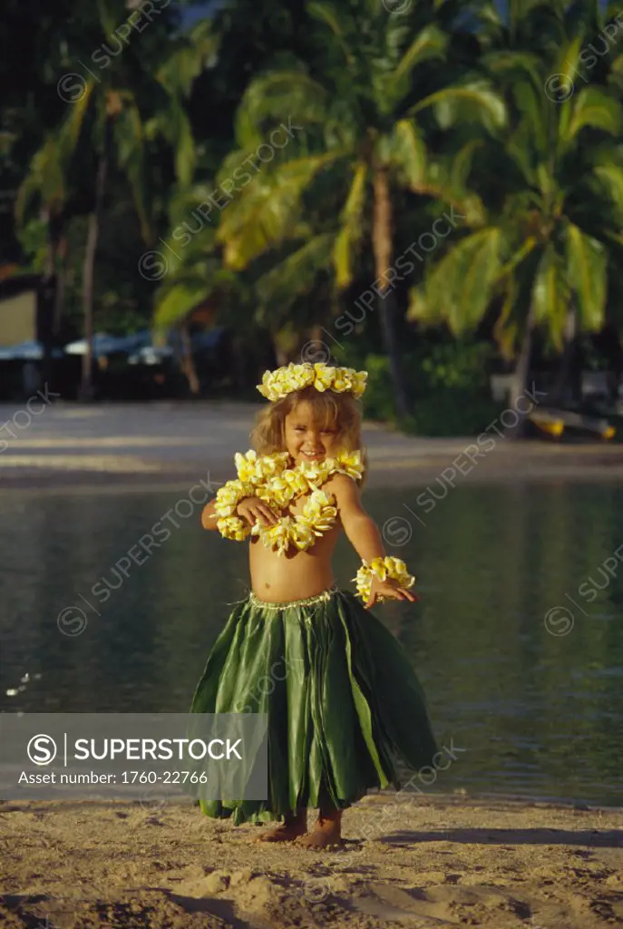 Hawaii, little hula girl on beach, with ti leaf skirt, plumeria lei.