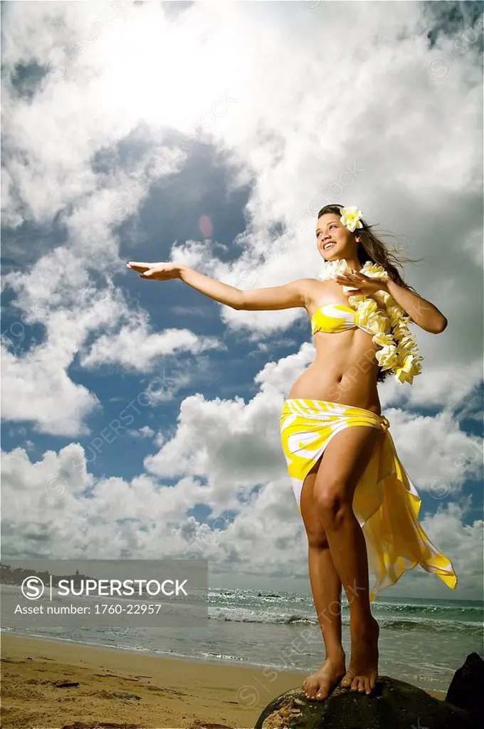 Hawaii, Kauai, Kealia, Beautiful Hawaiian girl dancing hula on ocean shoreline.