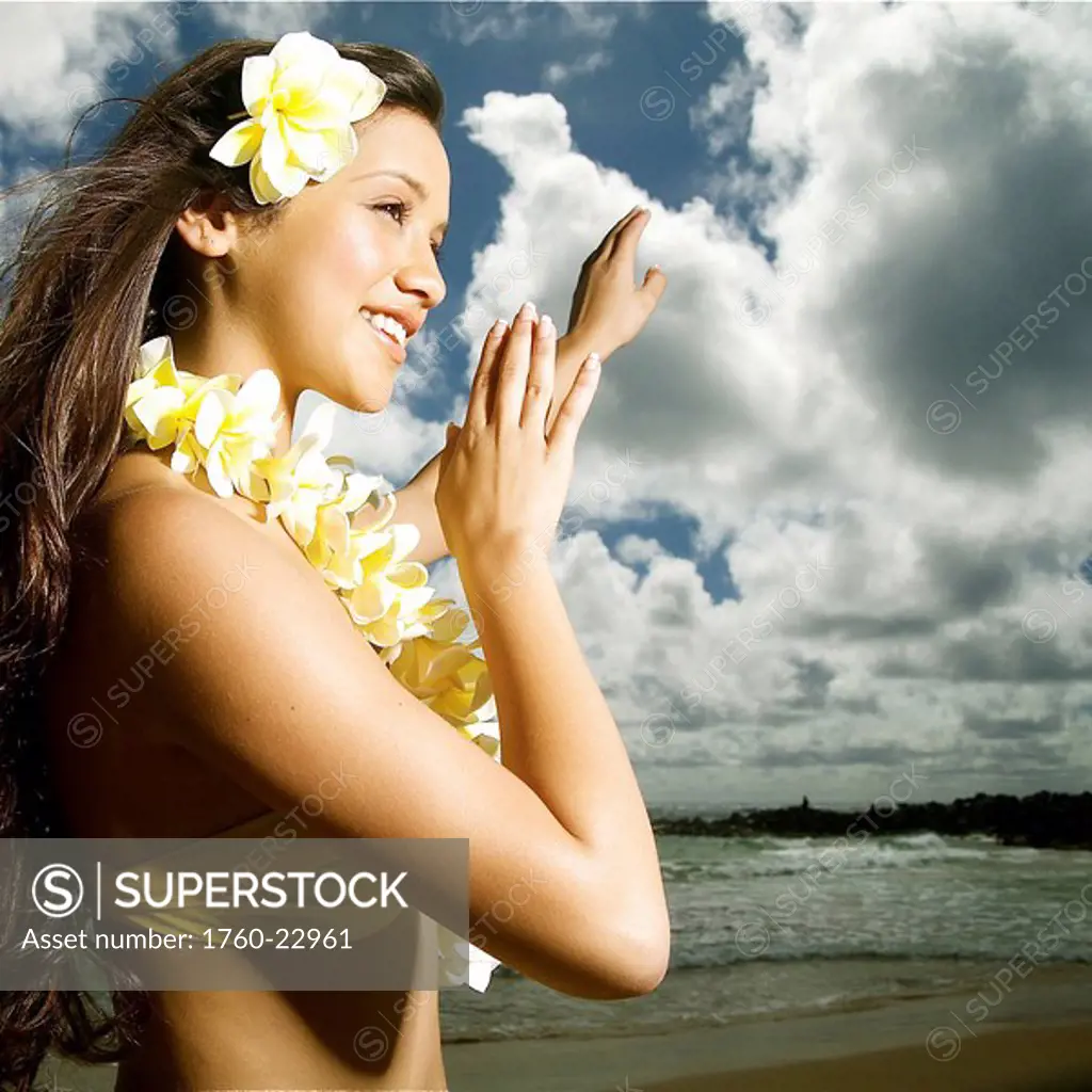 Hawaii, Kauai, Kealia, Beautiful Hawaiian girl dancing hula on ocean shoreline.