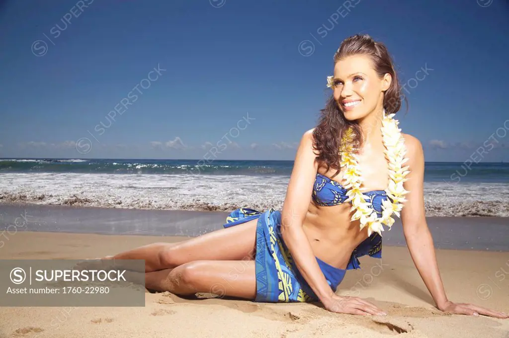 Hawaii, Kauai, Kealia, Beautiful woman dancing hula on ocean shoreline.