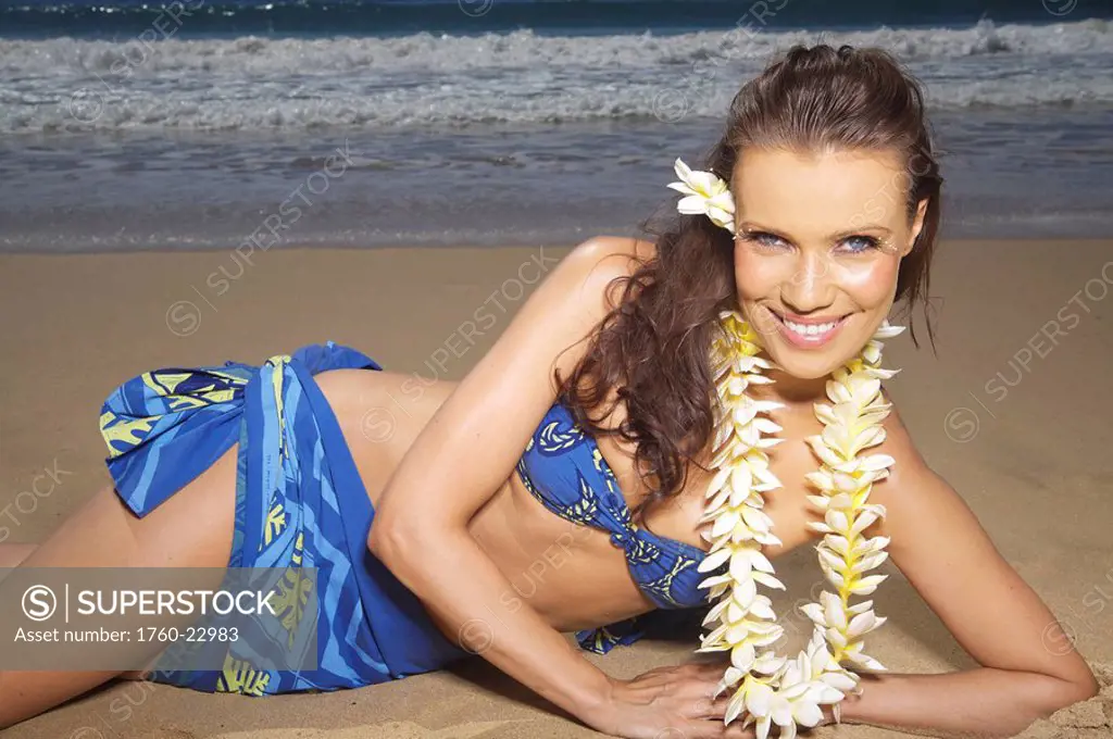 Hawaii, Kauai, Kealia, Beautiful woman dancing hula on ocean shoreline.