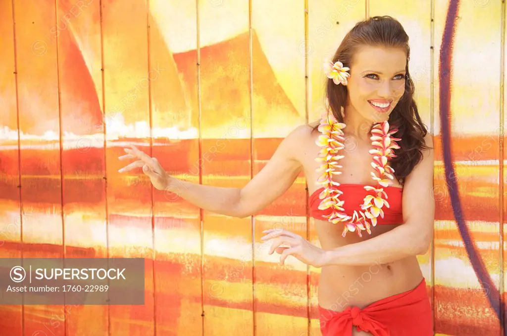 Hawaii, Kauai, Kapaa, Beautiful woman dancing hula on a beautiful painted backdrop of a beach.