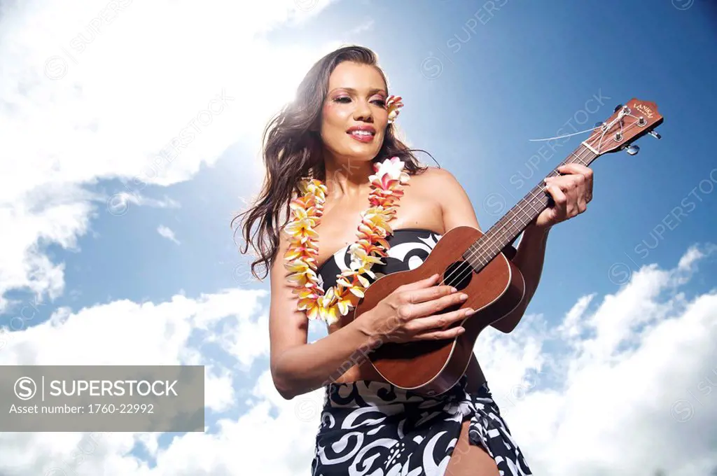 Hawaii, Kauai, Menehune Pond, Beautiful woman playing the ukulele.