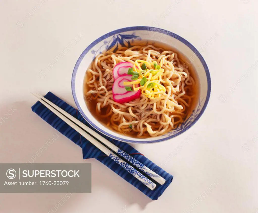 Studio shot of a bowl of Japanese Ramen with chopsticks on a napkin next to it.