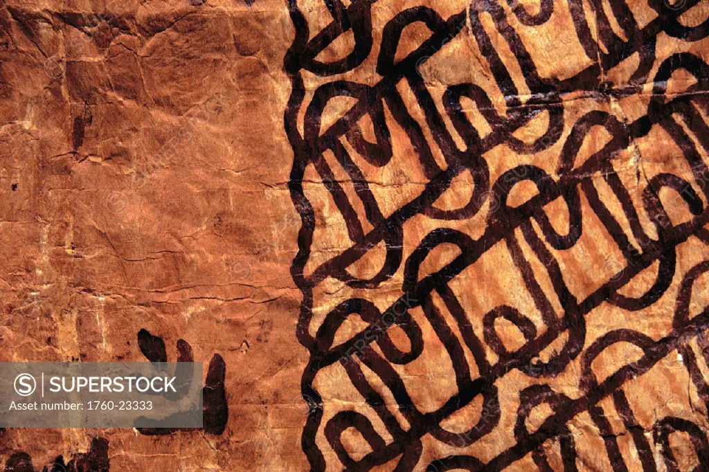 Closeup view of rust colored Tapa cloth material, bold design on left side