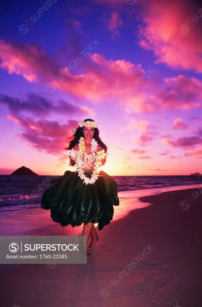 Hawaiian woman in hula attire, on the beach at sunrise, offering lei