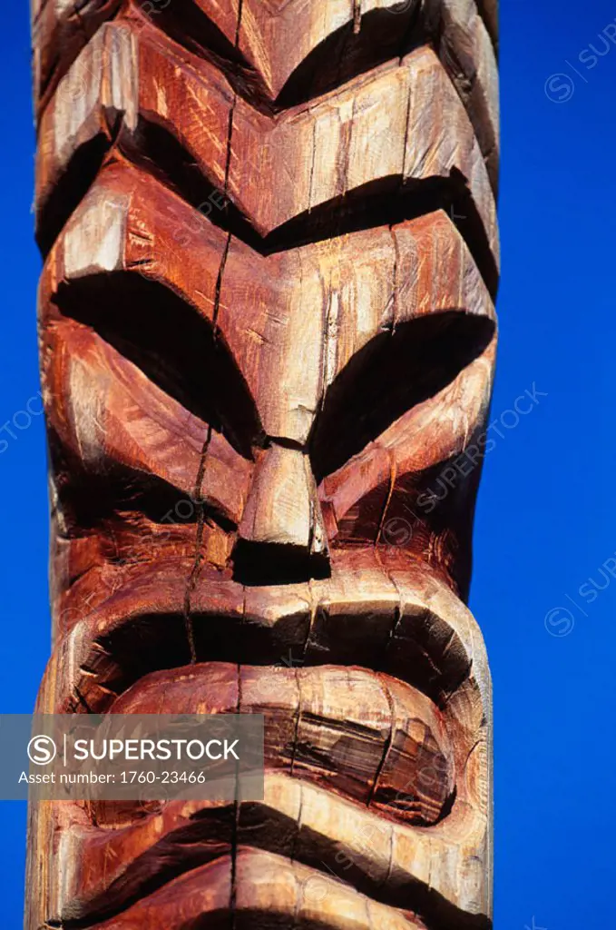 Hawaii, Maui, Lahaina Center, Hale Kahiko, closeup of wooden handcarved tiki, blue sky background