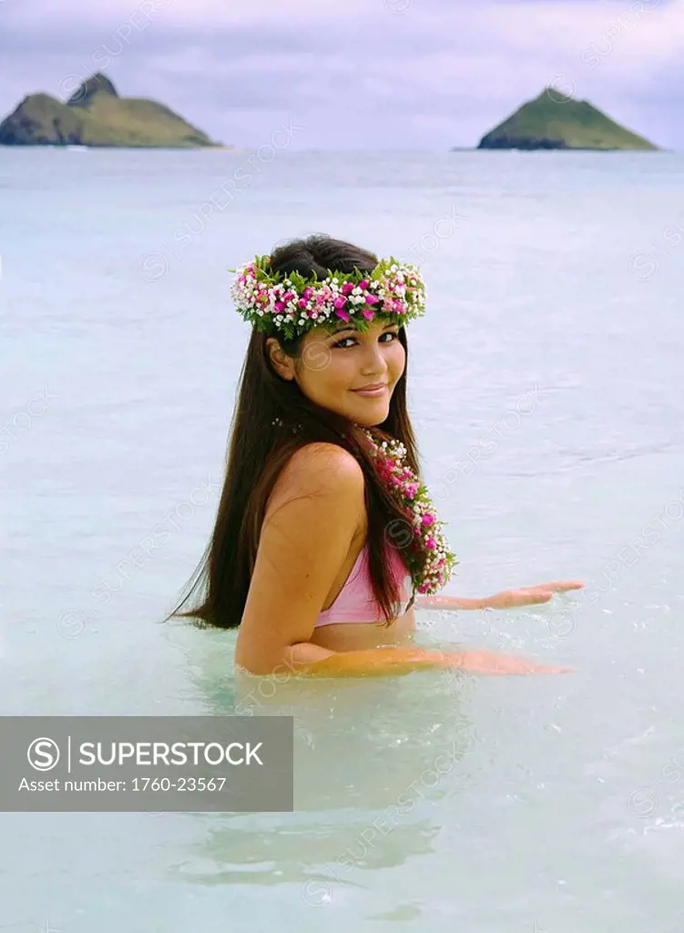 Hawaii, Oahu, Lanikai, Beautiful Hawaiian girl in haku and lei, wading in the ocean