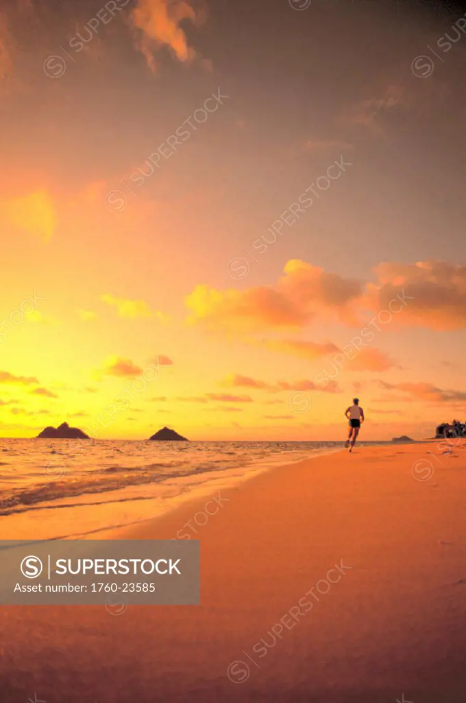 Hawaii, EastOahu, Lanikai, man running on beach with Mokulua Isles in bkgd