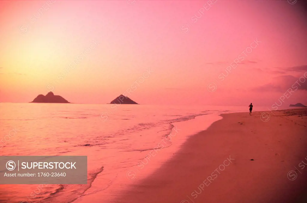 HI, man jogging on Lanikai Beach at sunrise, pink hues, Mokulua Islands in distance