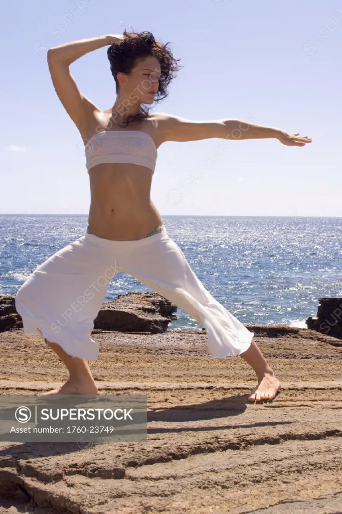 Hawaii, Oahu, young woman doing yoga next to the ocean.