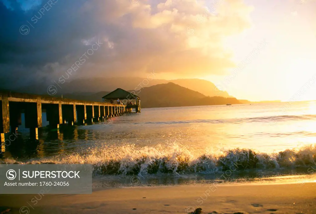 Hawaii, Kauai, Hanalei Bay and pier at sunset, golden sky with reflections.