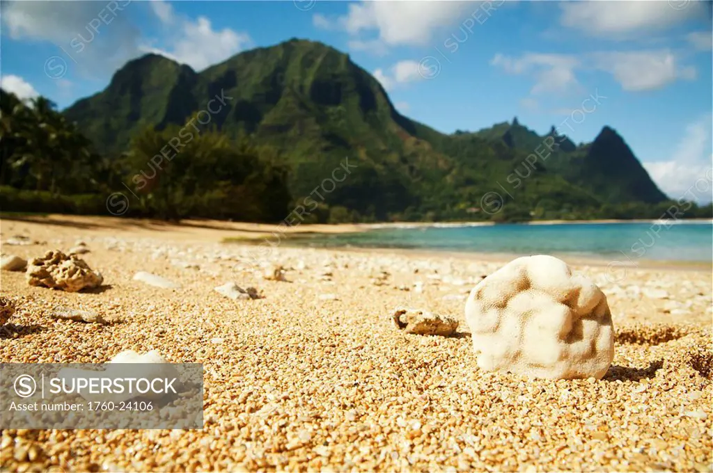 Hawaii, Kauai, North Shore, Tunnels Beach, Bali Hai Point with a sandy foreground in focus.