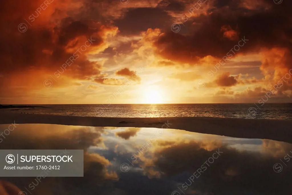 Hawaii, Oahu, North Shore, beach tidepool next to ocean reflecting the sunset sky.