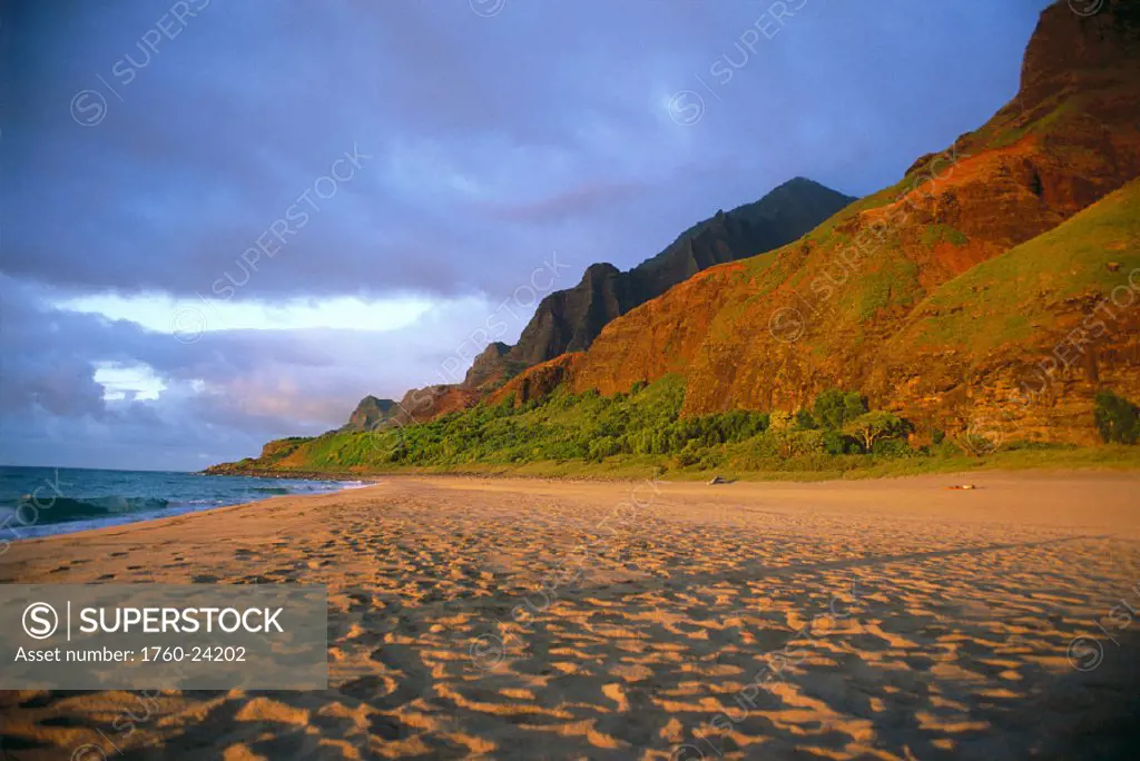 Hawaii, Kauai, NaPali Coast, Kalalau Beach w/ golden sand at sunset, kayak & tent bkgd