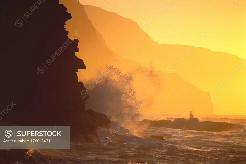 Kauai, NaPali Coast @ sunset from Haena, crashing waves against rocks, misty yellow sky