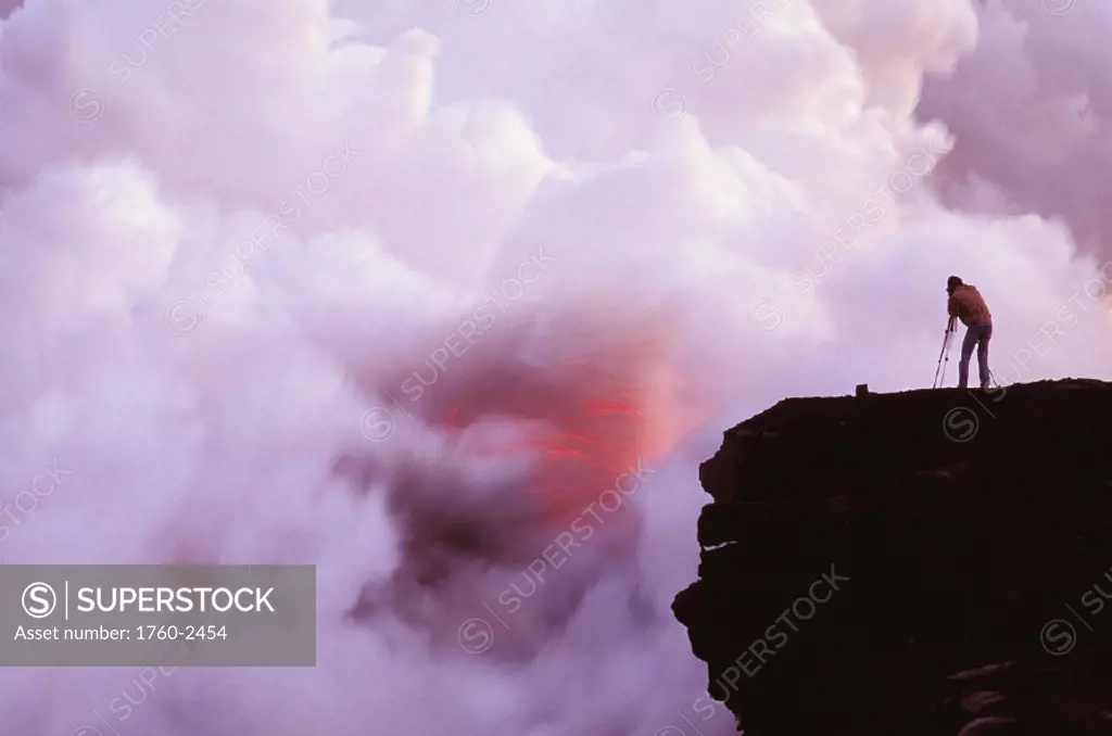 Hawaii, Big Island, Photographer on lava table filming lava flow into ocean