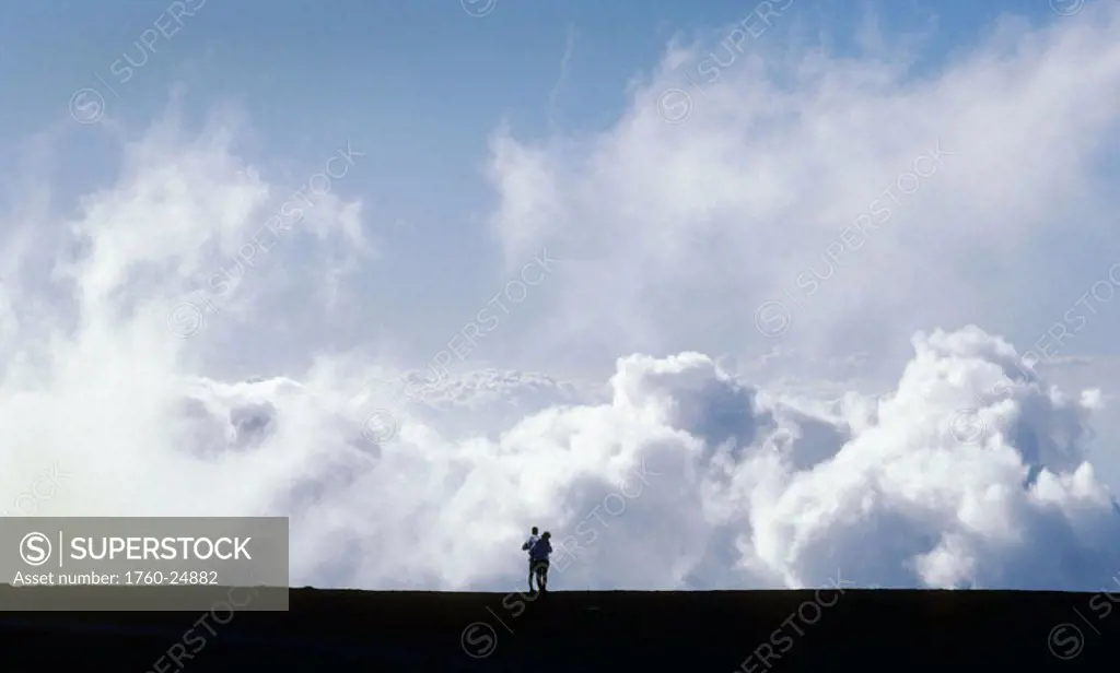 Hawaii, Maui, Haleakala Crater National Park, Couple looking down on giant clouds.