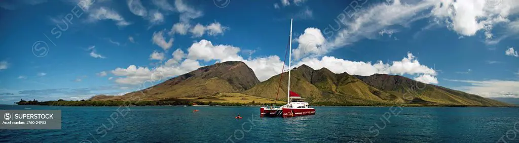 Hawaii, Maui, Olowalu and the west Maui mountains, A sailing catamaran floats on the ocean.
