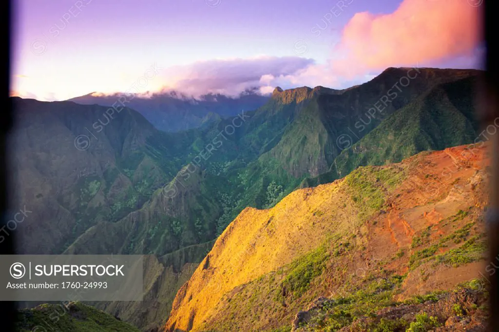 Hawaii, Maui, Ukumehame Gulch & West Maui Mountains at sunset, orange cloud, with green mtns in bkgd