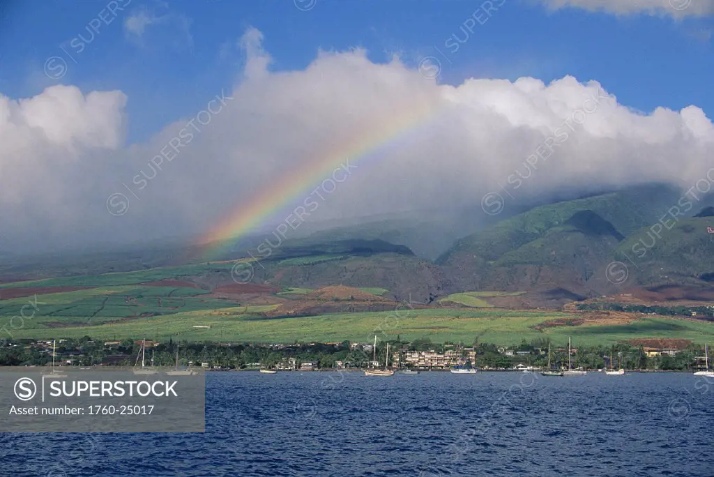 Hawaii Maui scenic view from across ocean to West Maui mtn w/ rainbow thru cloud
