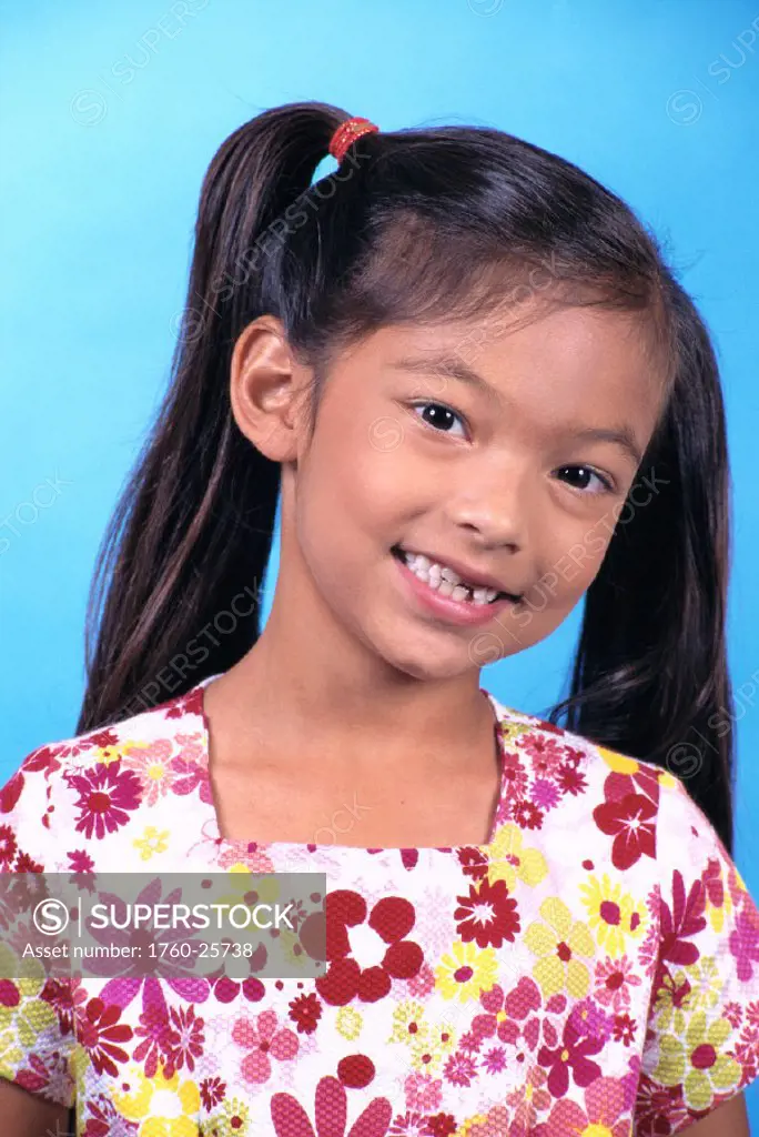 Closeup portrait of Local Asian girl w/ pigtails, smiling studio shot