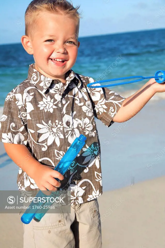 Hawaii, Oahu, Adorable little boy with an aloha shirt playing with bubbles.