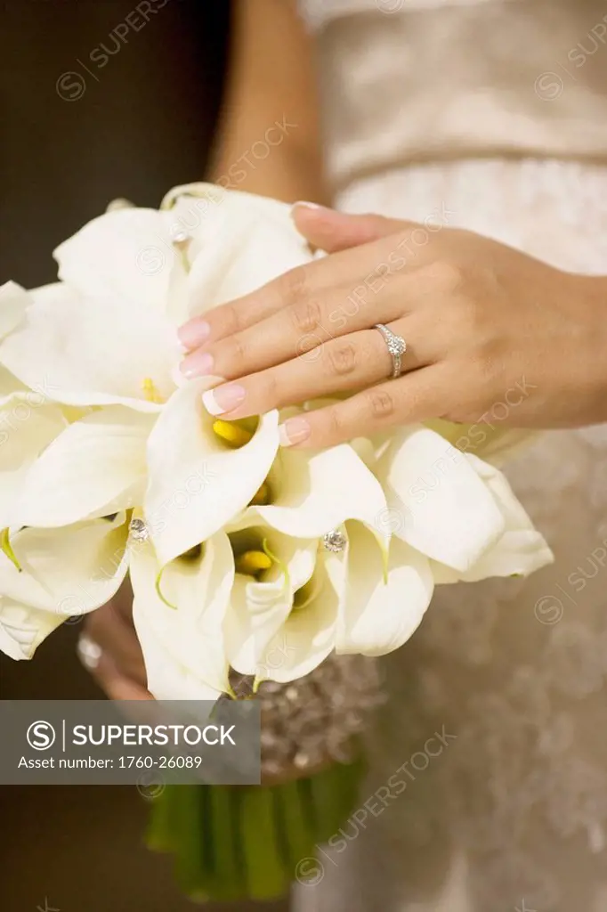 Hawaii, Oahu, Bride showing her bouquet and wedding ring.