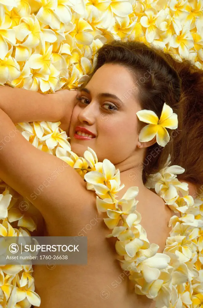 Hawaii, Hawaiian Girl laying on a bed of plumeria flowers,
