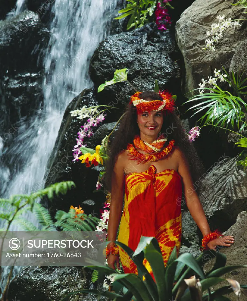 Polynesian woman standing by waterfall, Flower Leis, Tropical Plants.