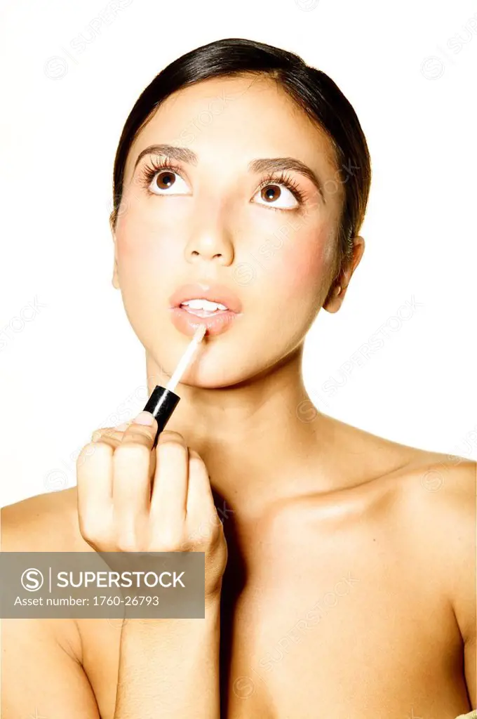 Hawaii, Studio headshot of a beautiful girl putting on lipstick.