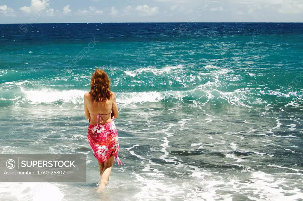 Hawaii, Big Island, Pololu Valley Black Sand Beach, Woman standing in the shorebreak.