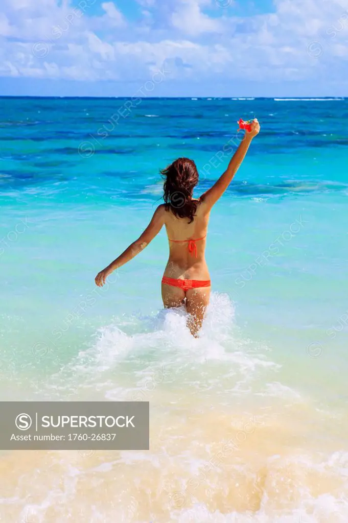 Hawaii, Oahu, Lanikai, Bikini_clad girl walking on beach, View from behind.