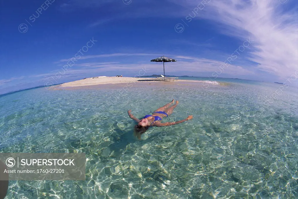 Fiji woman floats calm turquoise ocean off sand island D2032 beach chairs & umbrella, wide angle blue sky private